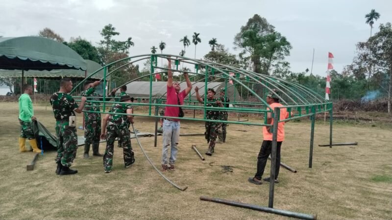 Personel Satgas TMMD ke-129 Kodim 0102/Pidie bersama warga bergotong royong menyiapkan lokasi upacara penutupan TMMD di Lapangan Bola Desa Lhok Panah, Kecamatan Sakti, Kabupaten Pidie, Rabu (12/8/2026).