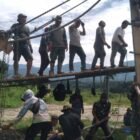 Personel Babinsa Kodim 0108/Agara bersama warga setempat bahu-membahu merangkai material pembangunan Jembatan Gantung Perintis di Desa Kumbang Jaya, Kecamatan Badar, Aceh Tenggara, Senin (17/8/2026).