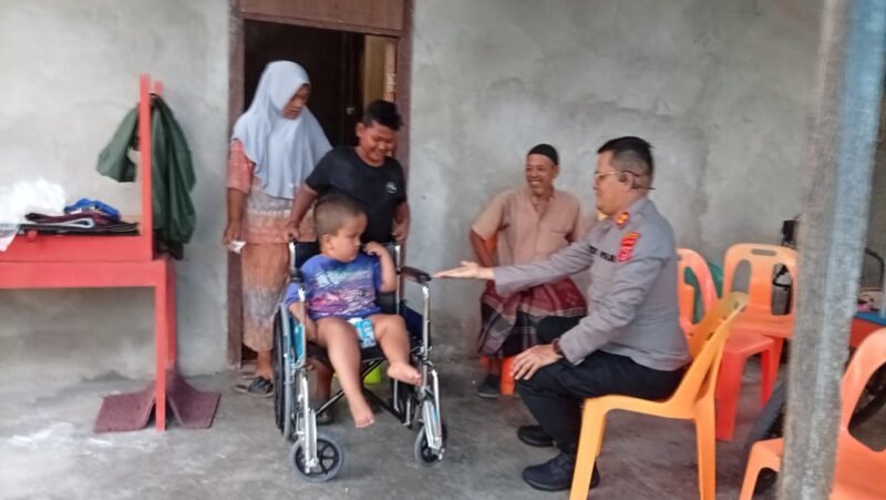 Kapolres Aceh Selatan AKBP T. Ricki Fadlianshah menyerahkan bantuan kursi roda dan paket sembako kepada Ikram (7), anak penyandang disabilitas di Gampong Lhok Pawoh, Kecamatan Sawang, Aceh Selatan, Selasa (18/8/2026).