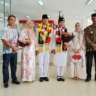 Camat Kuta Baro Zahrul Fuadi SE MM menyambut kepulangan Muhammad Hibban Annafis, anggota Paskibraka Nasional asal Gampong Cot Cut, di Bandara Sultan Iskandar Muda, Sabtu (22/8/2026).