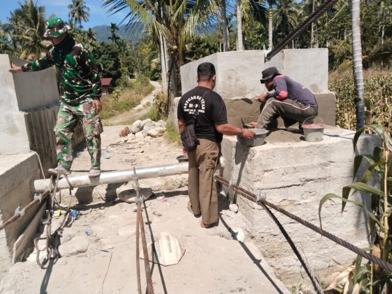 Babinsa Koramil/Posramil jajaran Kodam Iskandar Muda bersama warga bergotong royong merangkai besi dan mengecor pondasi dalam proses pembangunan Jembatan Gantung Perintis di Desa Lawe Pinis, Kecamatan Darul Hasanah, Kabupaten Aceh Tenggara, Minggu (23/8/2026).