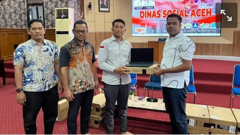 Anggota DPRA Ngohwan , Menyerahkan bantuan laptop secara simbolis kepada Koordinator Tim PKH Provinsi Aceh Dr. Deni Yacob di Aula Dinas Sosial Aceh, Kamis 10/09/2026.