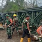 Personel TNI Koramil 06/Bukit bersama warga setempat bahu-membahu mengencangkan baut dan memasang komponen Jembatan Bailey di Desa Bale Redelong, Kecamatan Bukit, Kabupaten Bener Meriah. Hingga Selasa (15/9/2026),