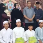 Wali Kota Banda Aceh, Hj. Iliza Sa'aduddin Djamal, S.E. (tengah), didampingi Ketua Baitul Mal Kota (BMK) Banda Aceh, Dr. Tgk. M. Yusuf Al-Qardhawy, M.H. (kiri), dan anggota DPRK Banda Aceh, Ramza Harli (kanan), menyerahkan bantuan secara langsung kepada salah satu penerima manfaat di Kota Banda Aceh, Selasa (1/9/2026).
