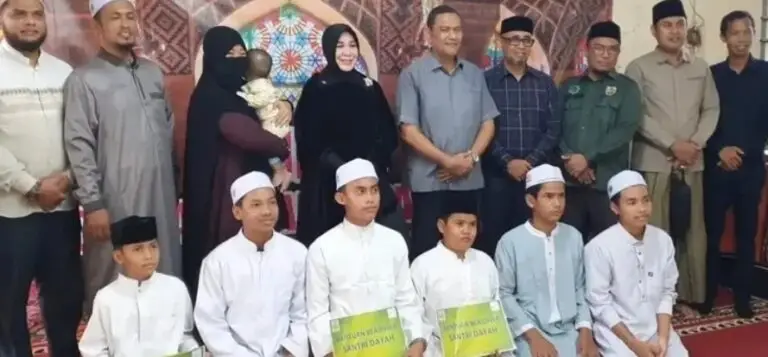 Wali Kota Banda Aceh, Hj. Iliza Sa'aduddin Djamal, S.E. (tengah), didampingi Ketua Baitul Mal Kota (BMK) Banda Aceh, Dr. Tgk. M. Yusuf Al-Qardhawy, M.H. (kiri), dan anggota DPRK Banda Aceh, Ramza Harli (kanan), menyerahkan bantuan secara langsung kepada salah satu penerima manfaat di Kota Banda Aceh, Selasa (1/9/2026).