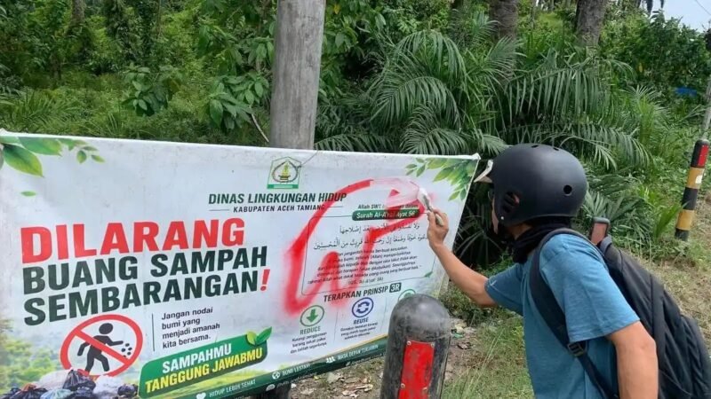Banner larangan buang sampah berayat Al-Qur'an di Jl Banda Aceh-Medan Kp Bukitrata Kejuruanmuda dicoret tak senonoh tepat di atas ayat, 7/10/2026.