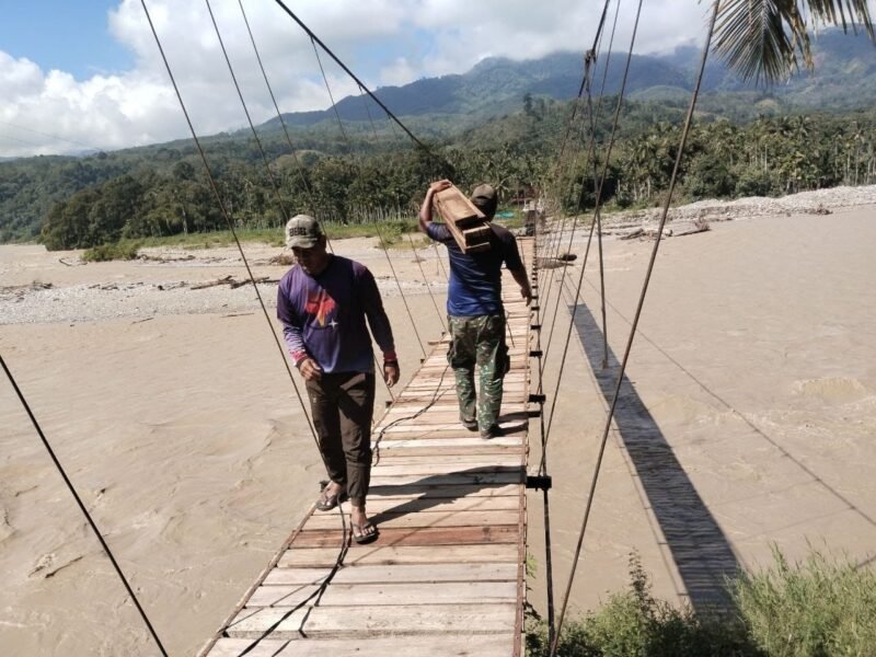 Warga dan TNI berkerja memasang papan jembatan, pada Selasa (20/10/2026). Foto: NA