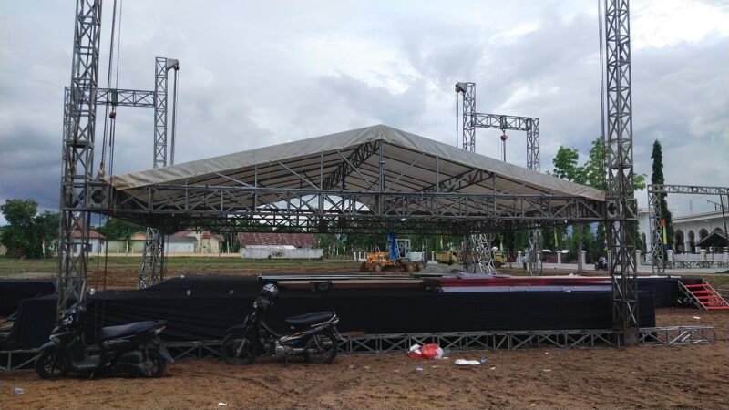 Pekerja mempercepat pemasangan panggung utama MTQ ke-35 tingkat Kabupaten Aceh Besar di Lapangan Bola Gampong Seupeu, Kecamatan Kuta Baro, Kamis (22/10/2026). Foto: NA