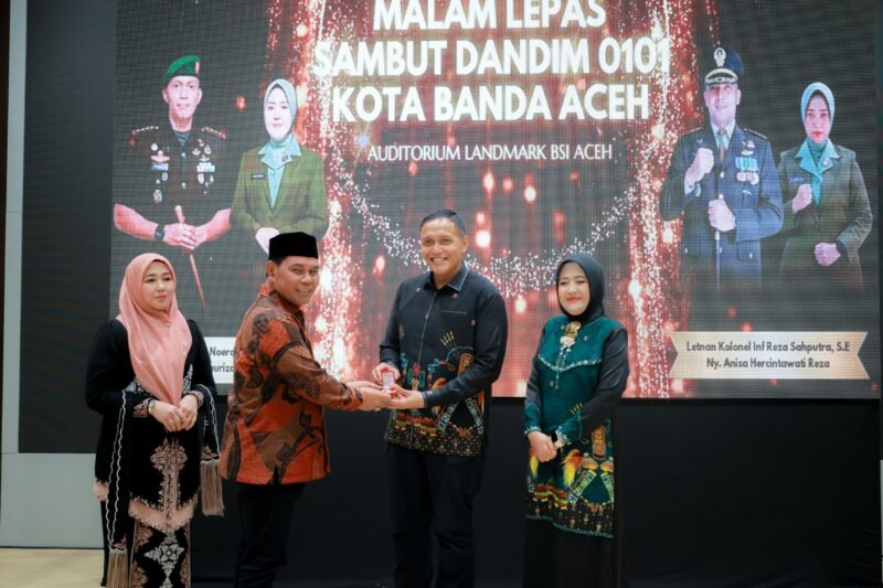Bupati Aceh Besar H Muharram Idris menyerahkan cenderamata kepada Dandim lama pada lepas sambut Komandan Kodim (Dandim) 0101/Kota Banda Aceh (KBA) di auditorium lantai 8 Landmark BSI Aceh, Banda Aceh, Jumat (23/10/2026) malam. Foto: NA