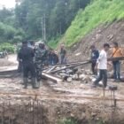 Babinsa Kodim 0108/Aceh Tenggara bersama warga bergotong royong mengangkat dan menyeberangkan material tiang pylon untuk pembangunan Jembatan Gantung Perintis di Desa Kuta Ujung, Kecamatan Darul Hasanah, Aceh Tenggara, Selasa (27/10/2026). Foto: NA