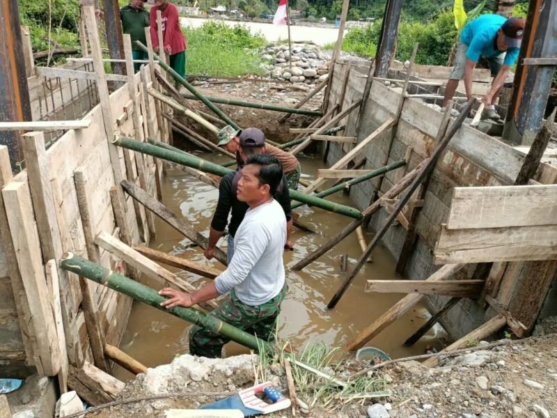 Babinsa Posramil Darul Hasanah Kodim 0108/Aceh Tenggara bersama masyarakat bergotong royong melaksanakan pengecoran tiang penahan jembatan gantung perintis di Desa Deleng Damar, Kecamatan Ketambe, Kabupaten Aceh Tenggara, Jumat (30/10/2026).